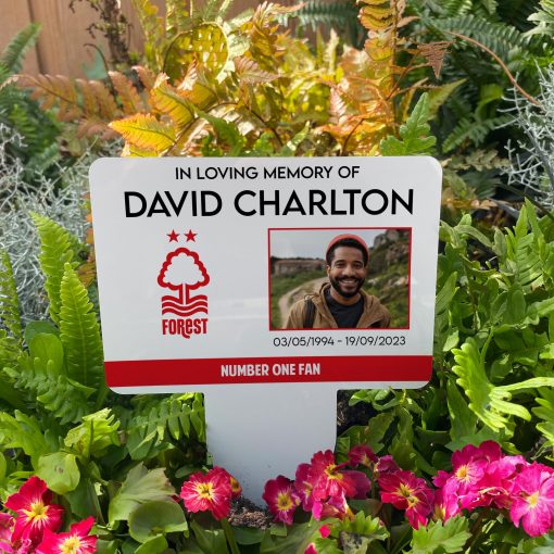 White Nottingham Forest football club memorial stake inserted in flower bed surrounded by colourful flowers in the garden