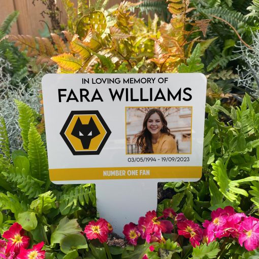 White Wolverhampton Wanderers football club memorial stake inserted in flower bed surrounded by colourful flowers in the garden